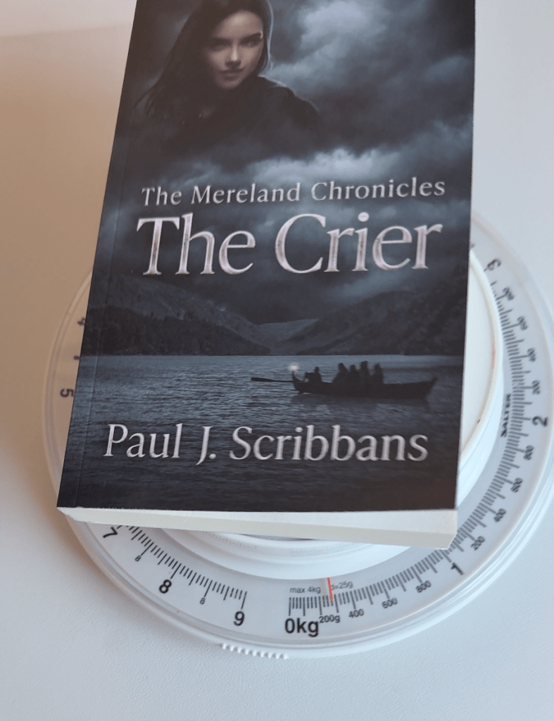 Amazon KDP Groundwood paperback of The Mereland Chronicles: The Crier on digital scales showing the lighter weight of the printed book compared with Standard White paper.