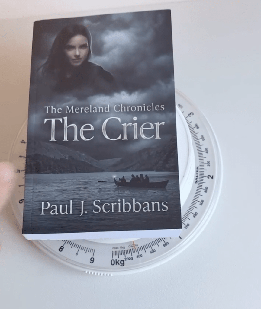 Amazon KDP Standard White paperback of The Mereland Chronicles: The Crier on digital scales showing the weight of the printed book for comparison with Groundwood paper.